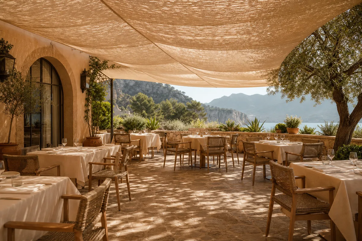 Voile d&rsquo;ombrage tendue au-dessus d&rsquo;une terrasse de restaurant, lumière tamisée